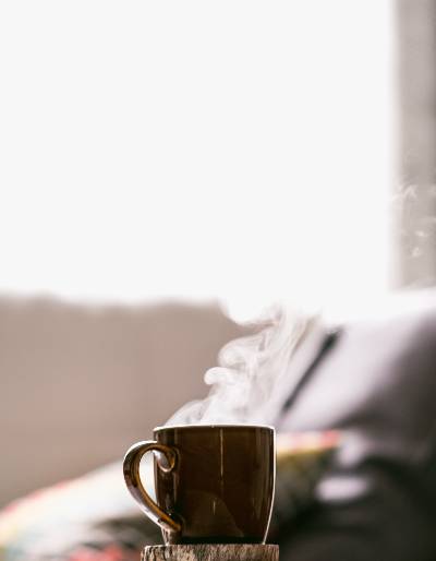 A Cup Of Coffee With A Steaming Hot Pot Of Coffee Sitting